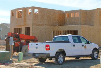 Truck in front on house being built